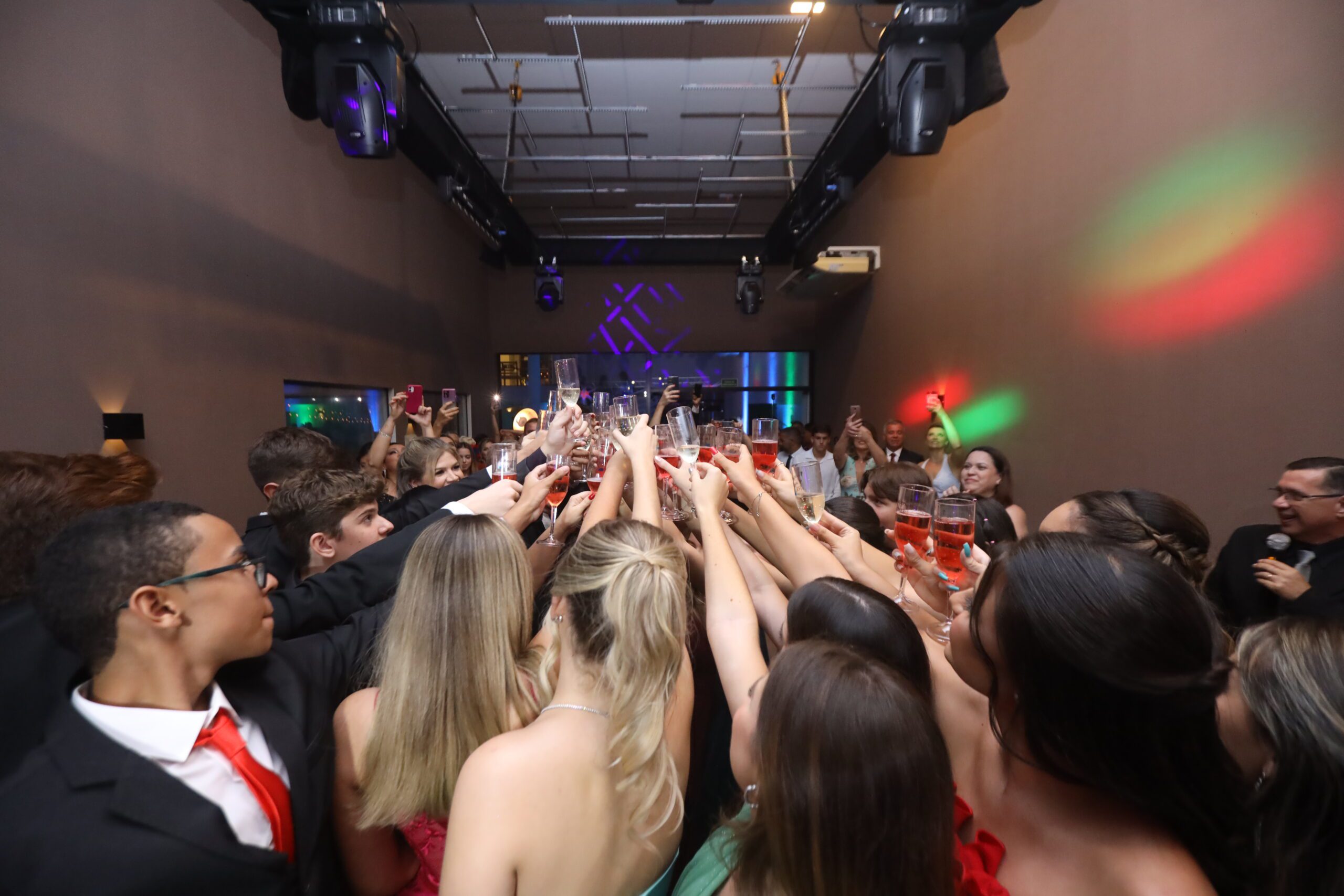 Formandos e convidados de braços levantados durante o show no baile de formatura organizado pela Talismã